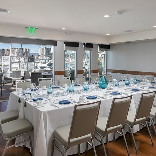 A bright conference room with a long glass table, white chairs, and a modern, airy setup&mdash;perfect for meetings and presentations.