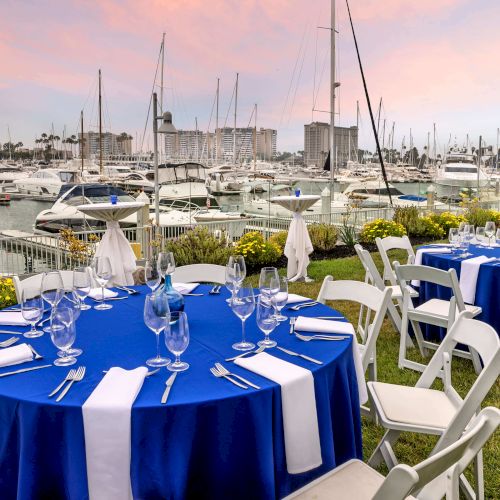 A marina with numerous sailboats docked, blue-and-white covers, calm water, and a bright, sunny day. ends with a period